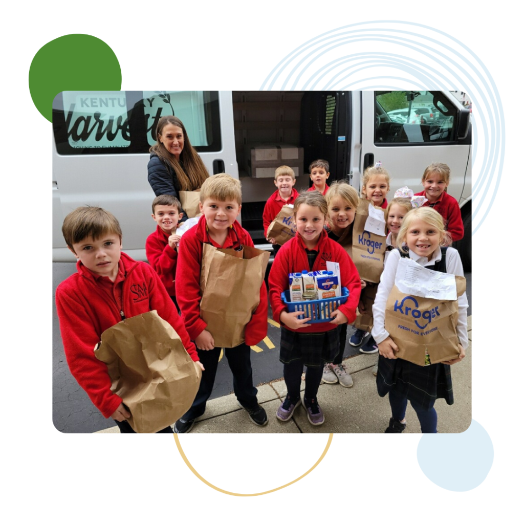 Group of young elementary-aged students carrying brown bags filled with food being donated to Kentucky Harvest.